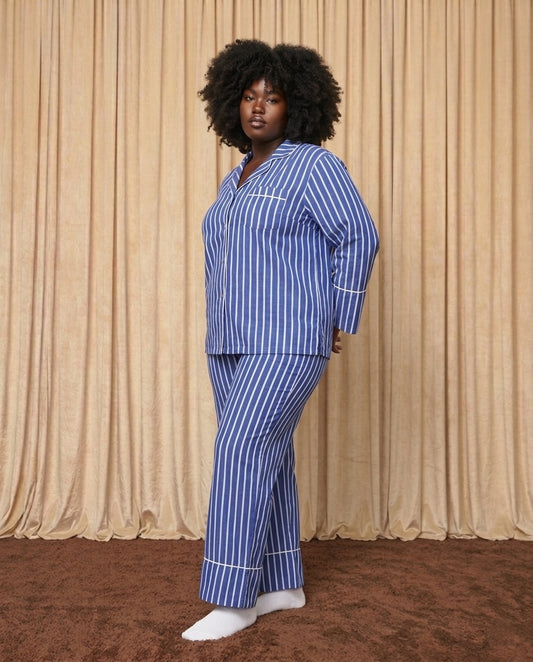 Woman wearing a blue and white cotton striped pyjamas.