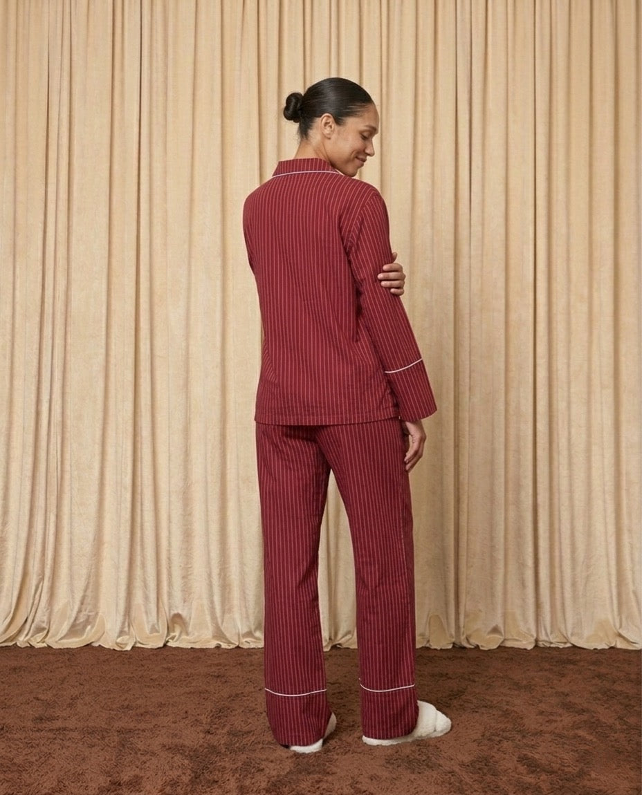 Woman wearing red and burgundy cotton striped pyjamas.