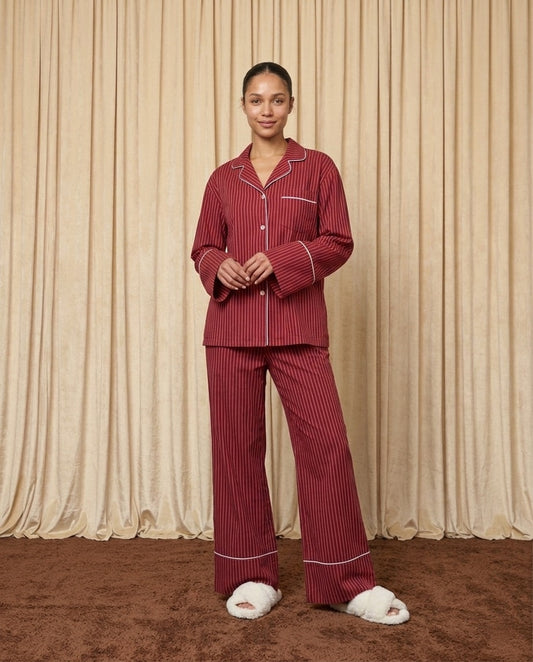 Woman wearing red and burgundy cotton striped pyjamas.