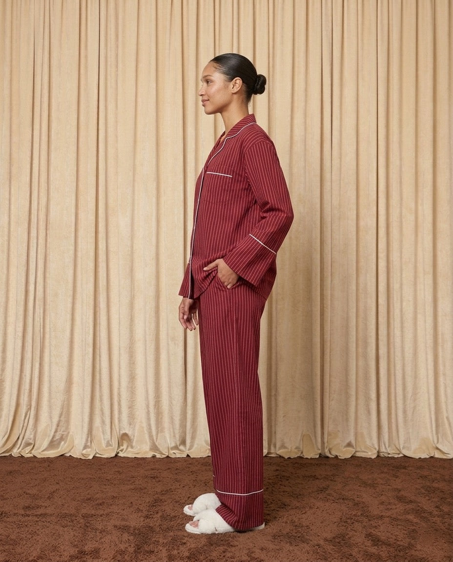 Woman wearing red and burgundy cotton striped pyjamas.