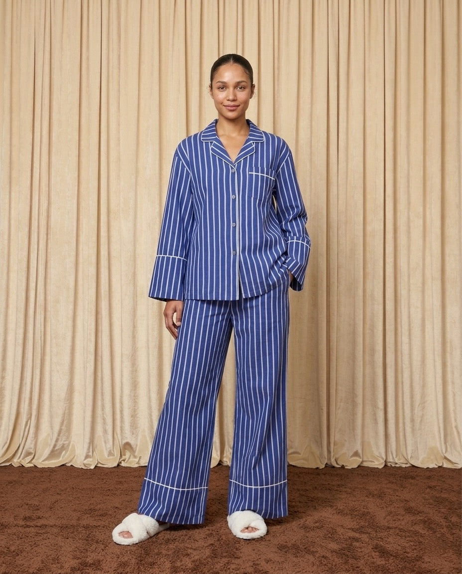 Woman wearing a blue and white cotton striped pyjamas.