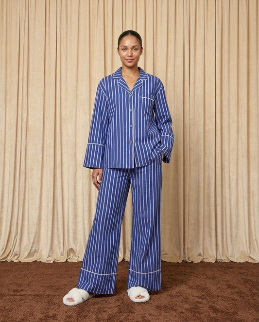 Woman wearing a blue and white cotton striped pyjamas.