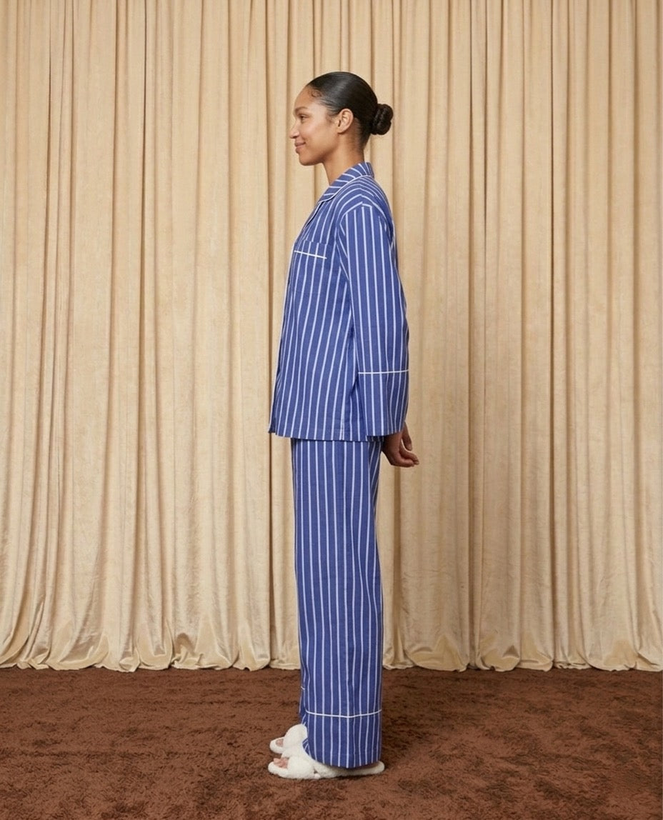 Woman wearing a blue and white cotton striped pyjamas.