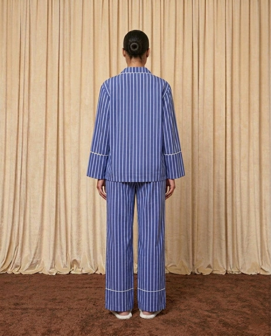 Woman wearing a blue and white cotton striped pyjamas.